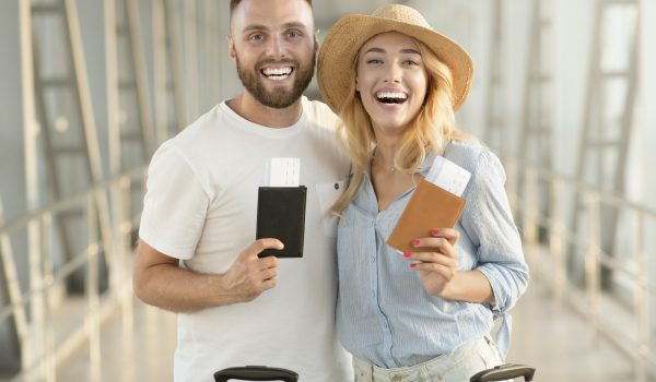 happy-couple-with-passports-and-tickets-at-airport-terminal.jpg